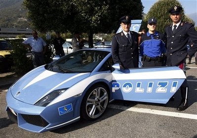 Two officers of Italian police, left and right, and their Swiss colleague pose near a Lamborghini Gallardo of Italian traffic police 'Polizia stradale', which is told to be the world's fastest police car, at a highway rest area in Bellinzona, southern Switzerland, Wednesday, Oct. 7, 2009. The Lamborghini will be presented at an international police meeting in the Netherlands. (AP Photo/Keystone/Kar
